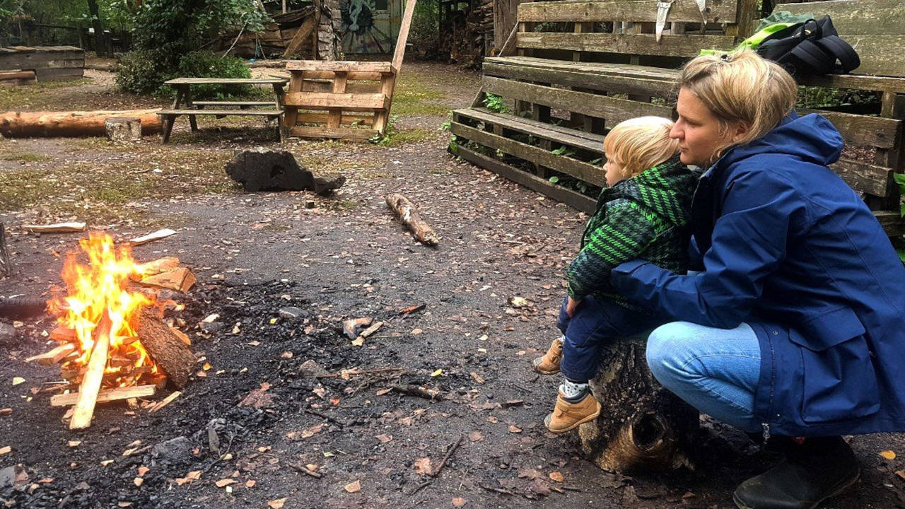 Mutter und Kleinkind am Lagerfeuer